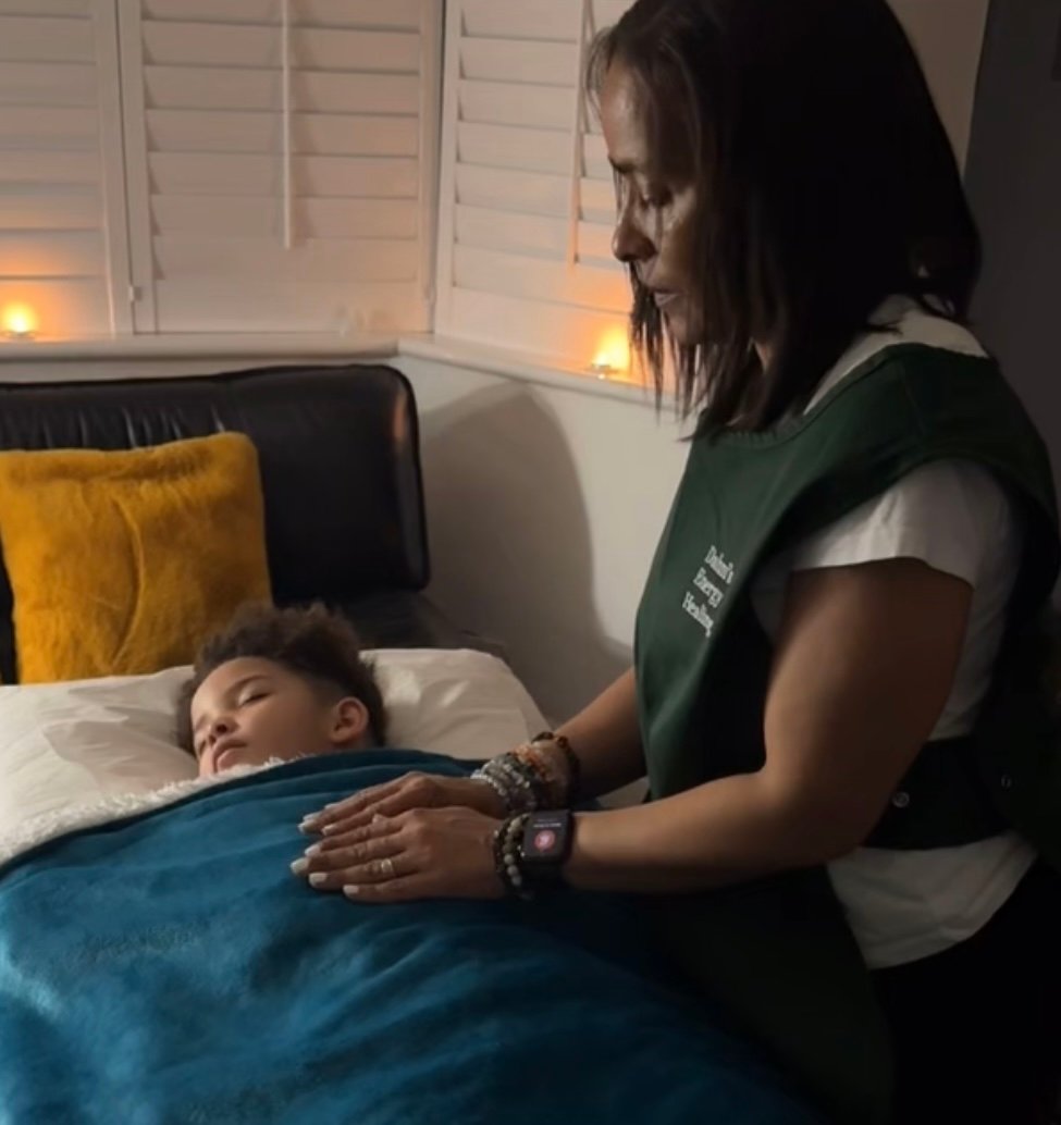 Dahni Reiki Therapist, giving Reiki Energy Healing to a child on the therapy couch/bed
