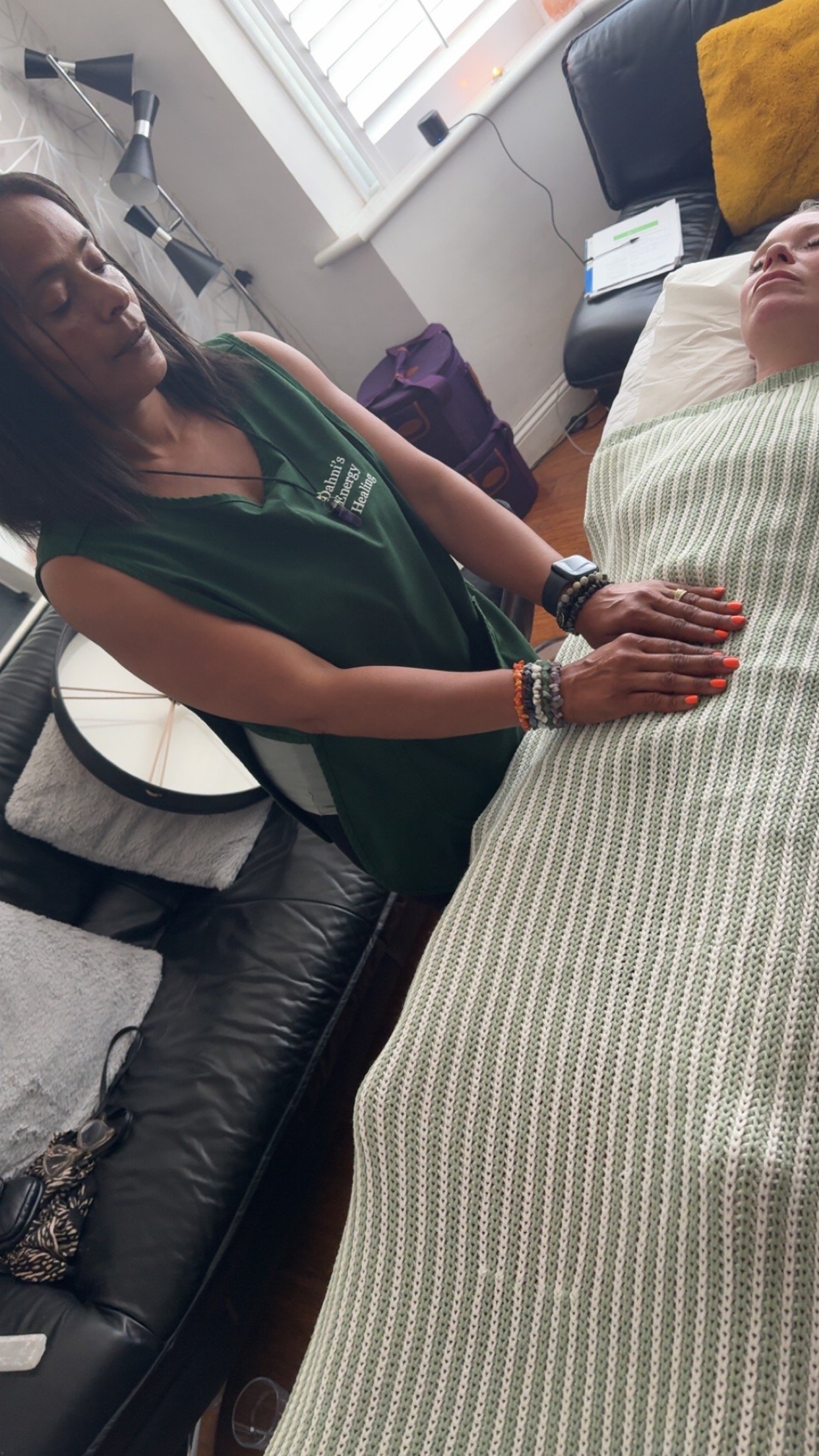A client laying on the therapy couch/bed whilst receiving Energy healing in London by Dahni a Reiki practitioner