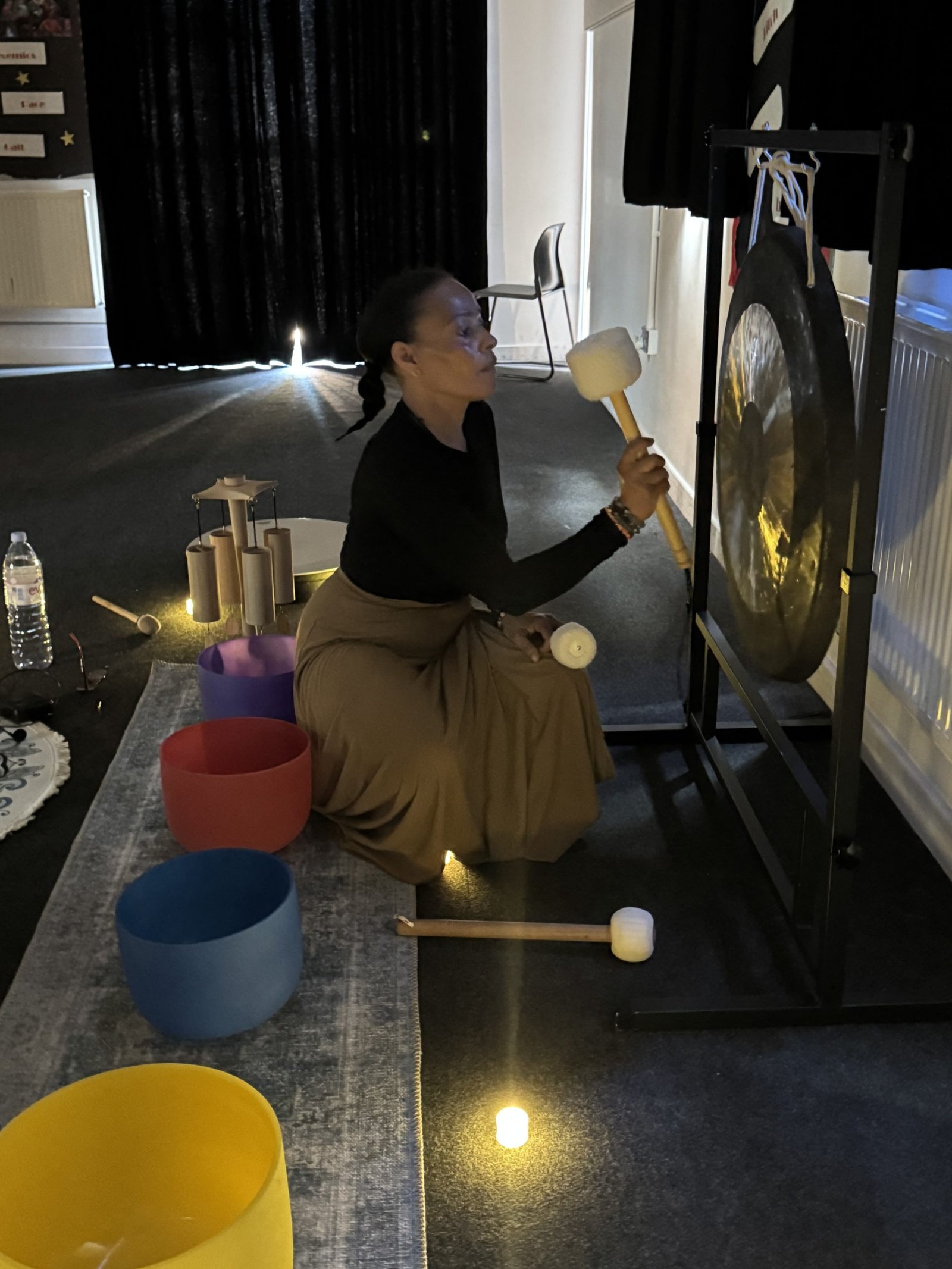 Dahni Sound Healing therapist playing the Gongs and sound bowls at a sound bath event