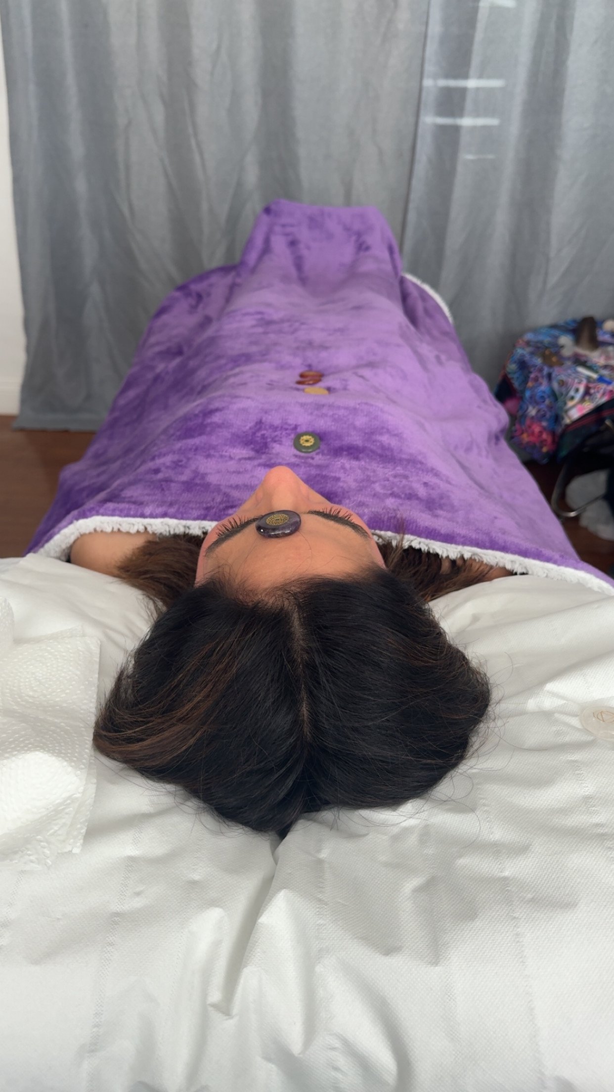 Client Laying on therapy Couch/Bed, whilst receiving Reiki Healing from Holistic wellness practitioner Dahni