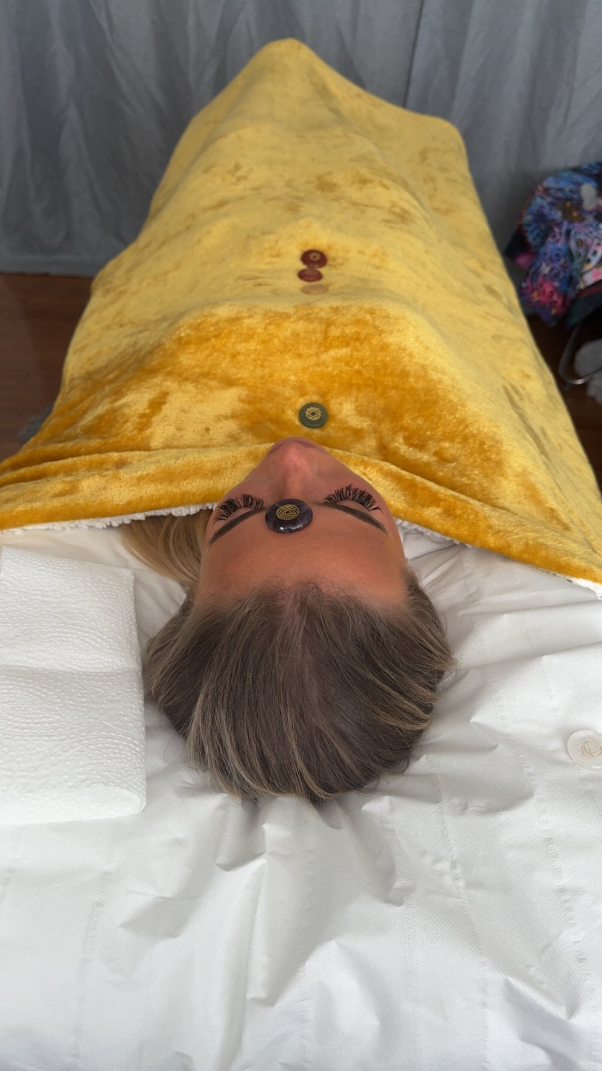 Client receives Reiki from Dahni holistic wellness therapist, whilst laying on the therapy Couch/Bed with Crystals placed along the Chakras