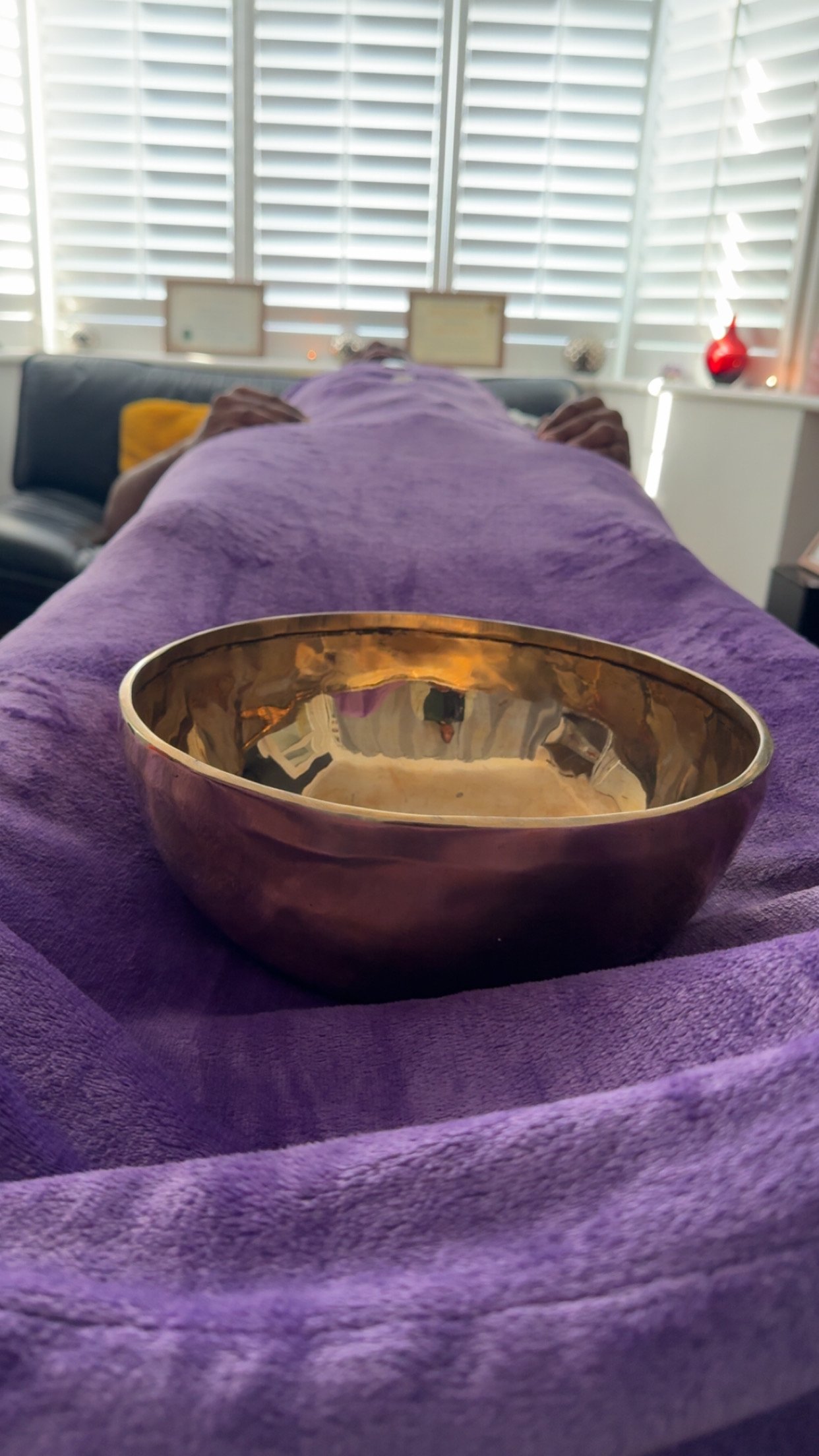 Tibetan Singing Bowl positioned on a client laying on the therapy Couch/Bed, whilst receiving Reiki and Sound healing