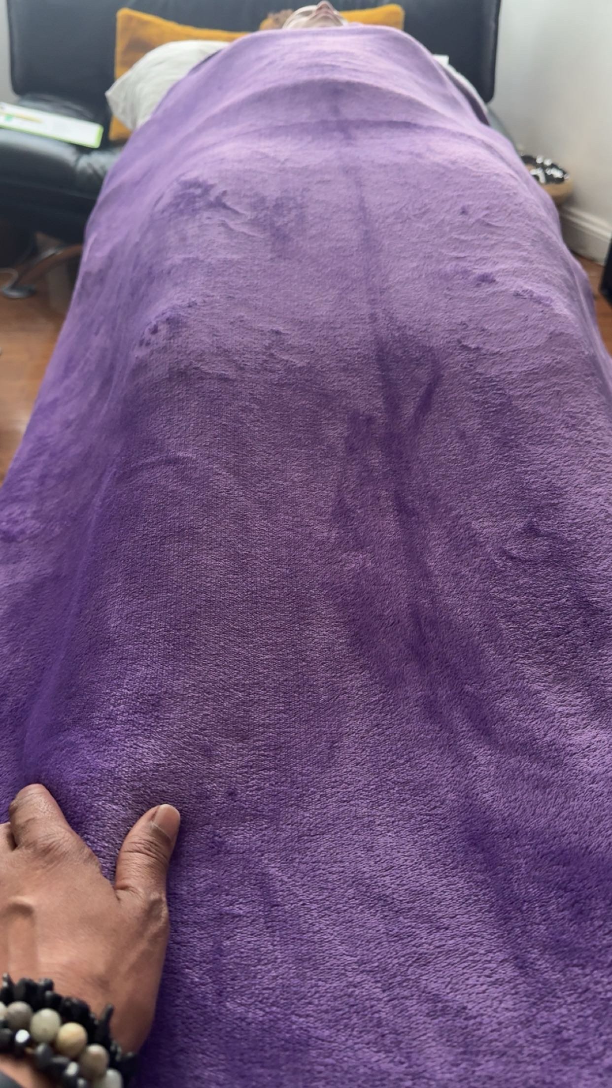 Dahni Reiki practitioner with hand on Client who is laying on the therapy couch/bed, whilst receiving a Reiki Healing session