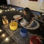 Dahni sound therapy practitioner, playing the Quartz crystal sound bowls at a sound bath event